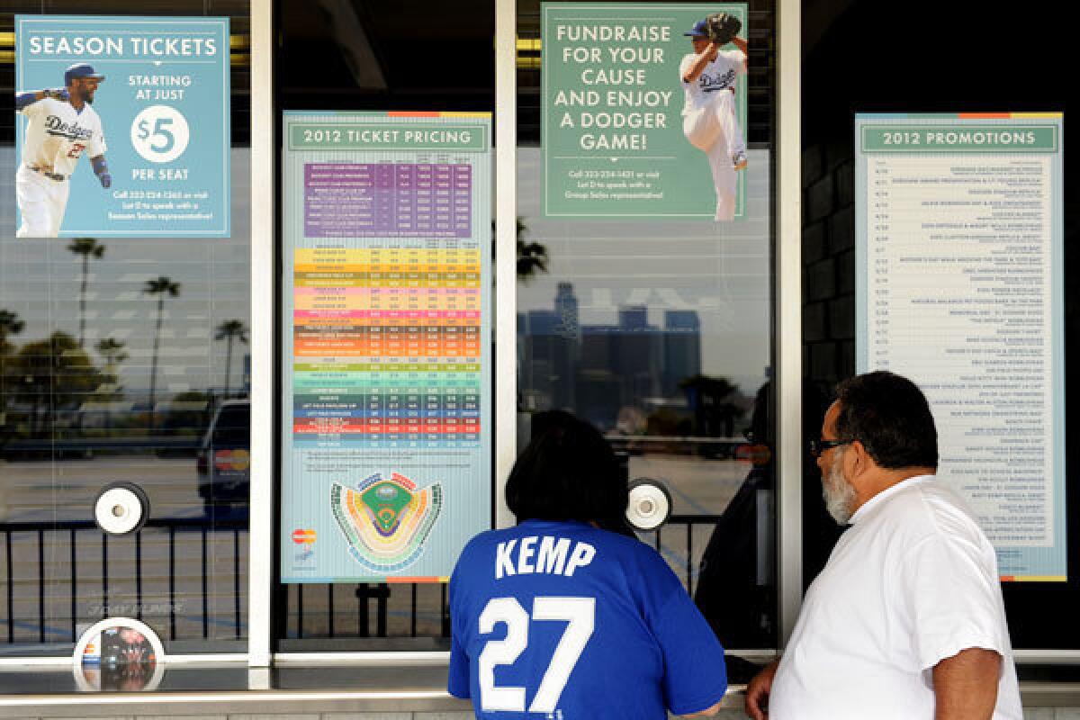 Terri and Jerry Apodaca purchase Dodger tickets outside Dodger Stadium where a group headed by Magic Johnson bought the Dodgers for $2 billion.