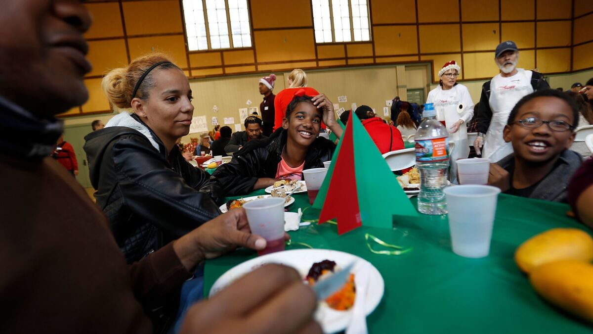 Wayne Mingo, from left, Emmethia Smith, Kaliyah Smith and Jeremiah Mingo enjoy a free Christmas meal at Hollywood United Methodist Church.