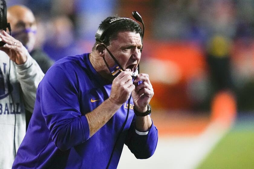 FILE - In this Saturday, Dec. 12, 2020 file photo, LSU coach Ed Orgeron shouts instructions to players on the field during the first half of the team's NCAA college football game against Florida in Gainesville, Fla. LSU coach Ed Orgeron has hired Jake Peetz as his offensive coordinator and DJ Mangas as passing game coordinator, luring both coaches away from the NFL's Carolina Panthers. Peetz and Mangas, whose hirings were announced Wednesday, Jan. 6, 2021 both worked as offensive assistants alongside Panthers offensive coordinator and former LSU passing game coordinator Joe Brady.(AP Photo/John Raoux, File)