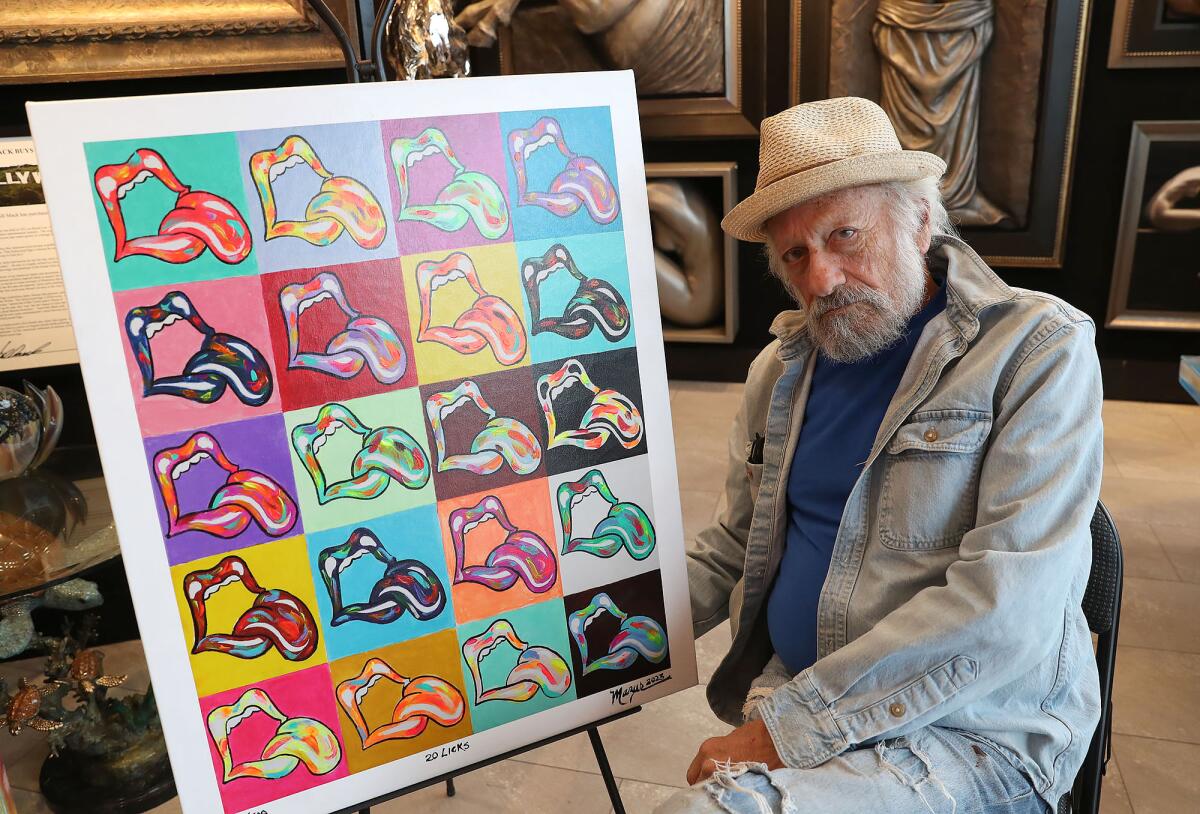 Ruby Mazur sits next to his "20 Licks" piece at the Bill Mack Gallery in Laguna Beach. 