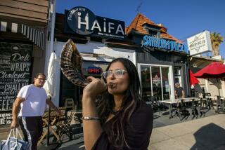 LOS ANGELES, CA-SEPTEMBER 7, 2023: Sarah Afkami, a Hollywood writer for the past decade, is photographed with her shofar on Pico Blvd. near her home in Los Angeles. Now after months on strike, she's looking to the Jewish High Holidays as an opportunity to reimagine what her life in L.A. will look like for the foreseeable future, and leaning hard on the support of her community in the Pico Robertson neighborhood. (Mel Melcon / Los Angeles Times)
