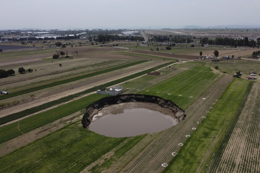 Un socavón con agua en el fondo continúa creciendo en un campo agrícola en Zacatepec, en las afueras del estado de Puebla, México, el martes 1 de junio de 2021. (AP Foto/Pablo Spencer)