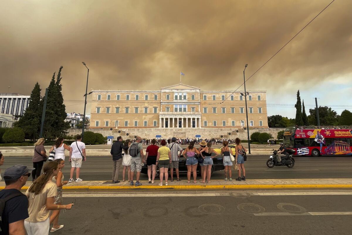 Smoke from wildfires is seen above the Greek parliament building in Athens.