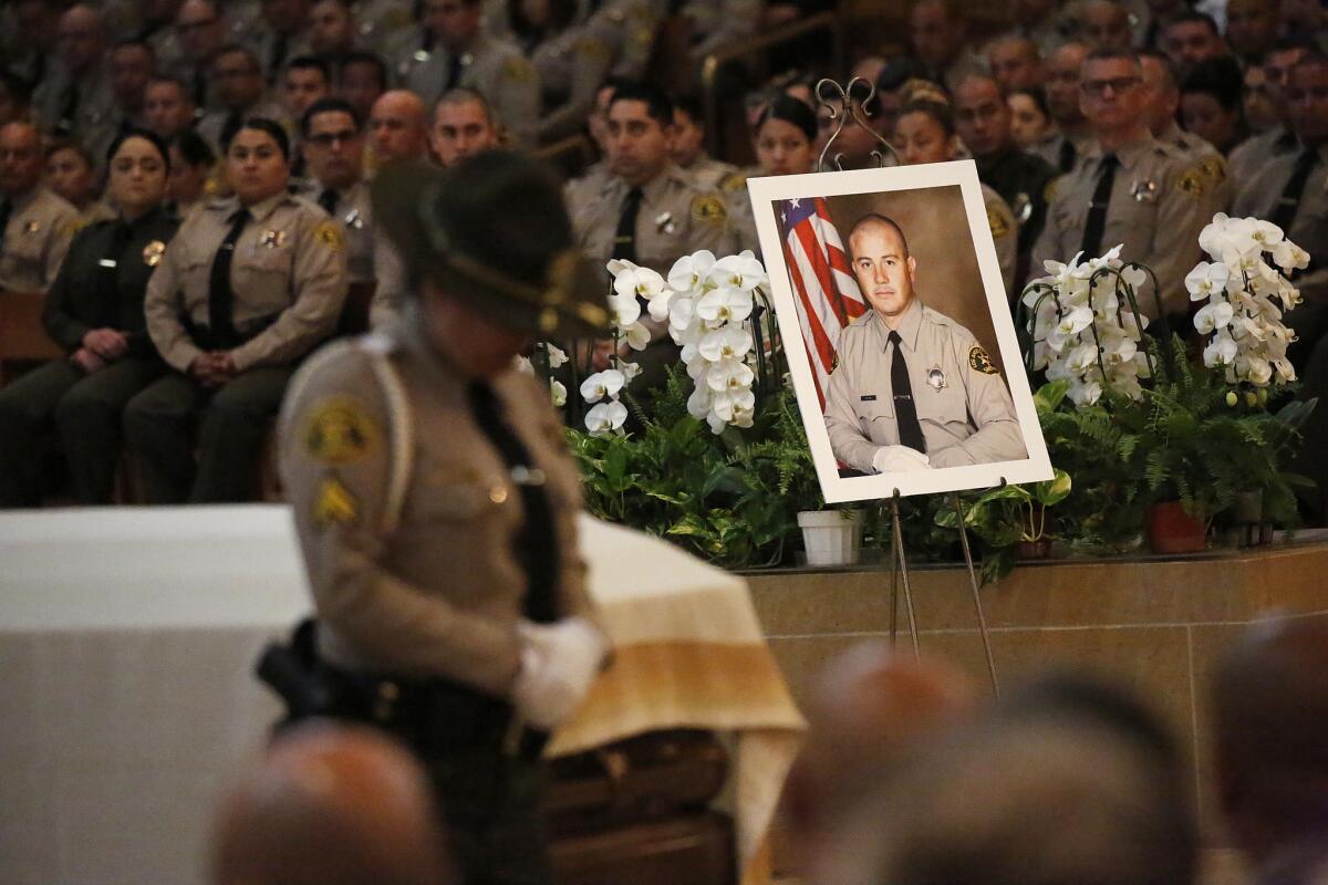 A portrait sits next to the casket of Los Angeles County Sheriffs Deputy Joseph Solano during a memorial service June 24 at the Cathedral of Our Lady of the Angels in Los Angeles.