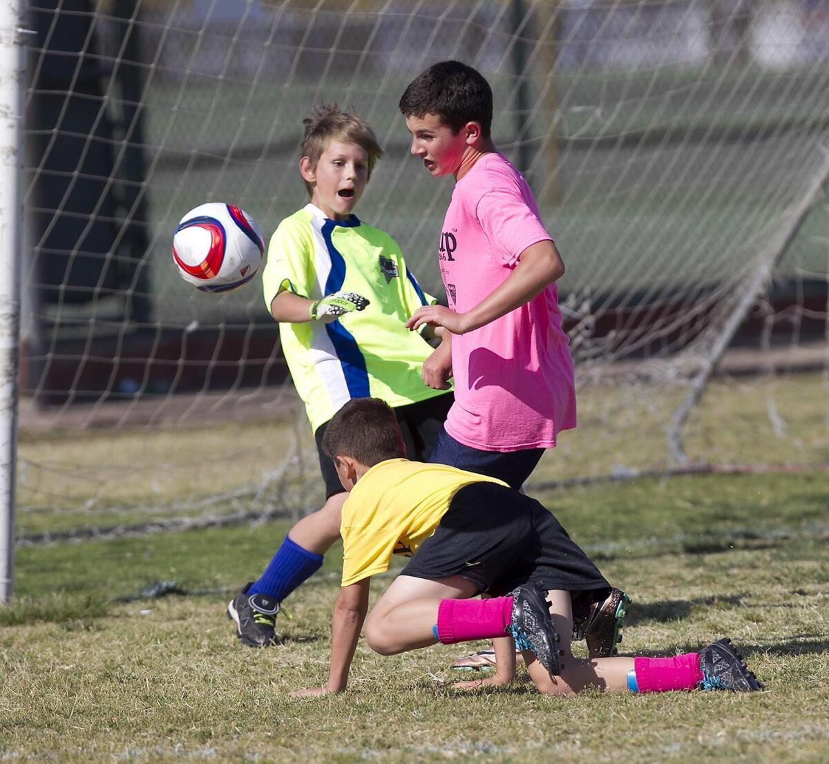Carden Hall goalie Garrett Richards jumps in to stop a point-blank shot by St. Joachim's Ben Chiano, in pink, in a boys' 5-6 Silver Division game of the Pilot Cup on Thursday.
