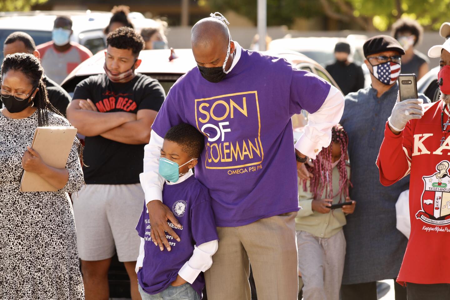 Hospital Chaplain Charles Clemons puts an arm around son John, 7.