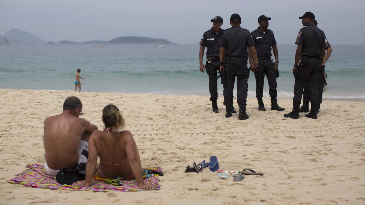 Police stand guard on Arpoador beach in Rio de Janeiro last September. Rio's state Security Secretary said he will deploy the largest contingent of police and soldiers in Brazilian history to guard the upcoming Olympic Games.