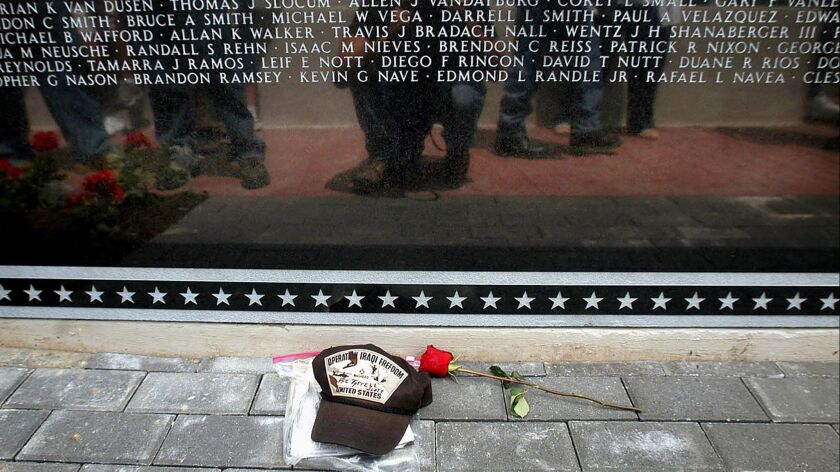Viewers are reflected in the Middle East Conflicts Wall Memorial during its dedication ceremony in Marseilles, Ill. on June 19, 2004.