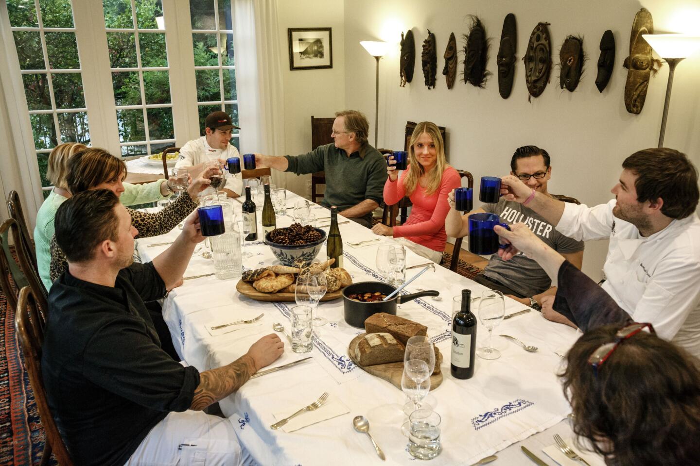 Guests toast during a dinner prepared by Chef Bernhard Mairinger of BierBeisl, right, as a demonstration of an Austrian Christmas, at the home of Richard Sparks and Jenny Okun.