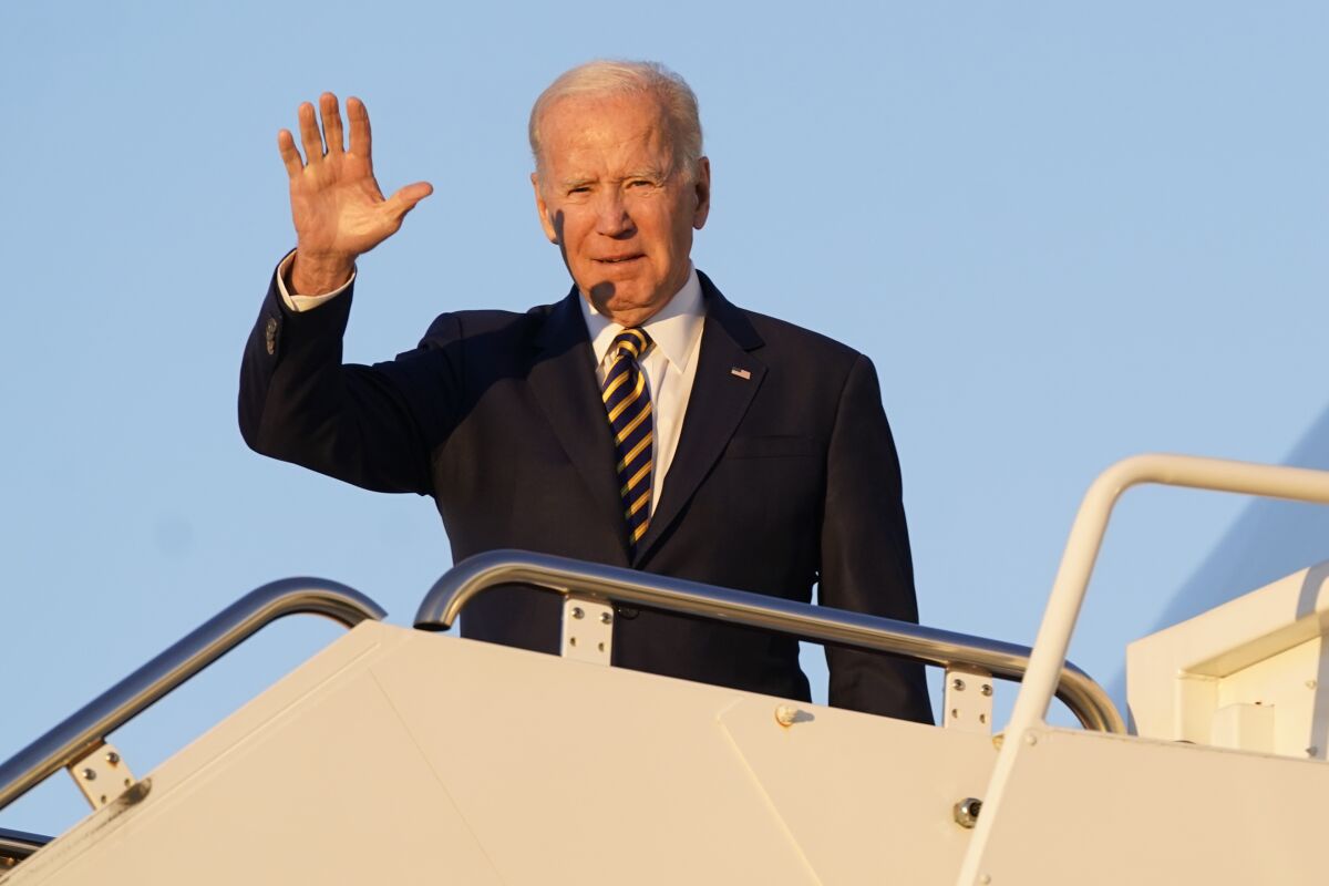 President Joe Biden waves as he boards Air Force One.