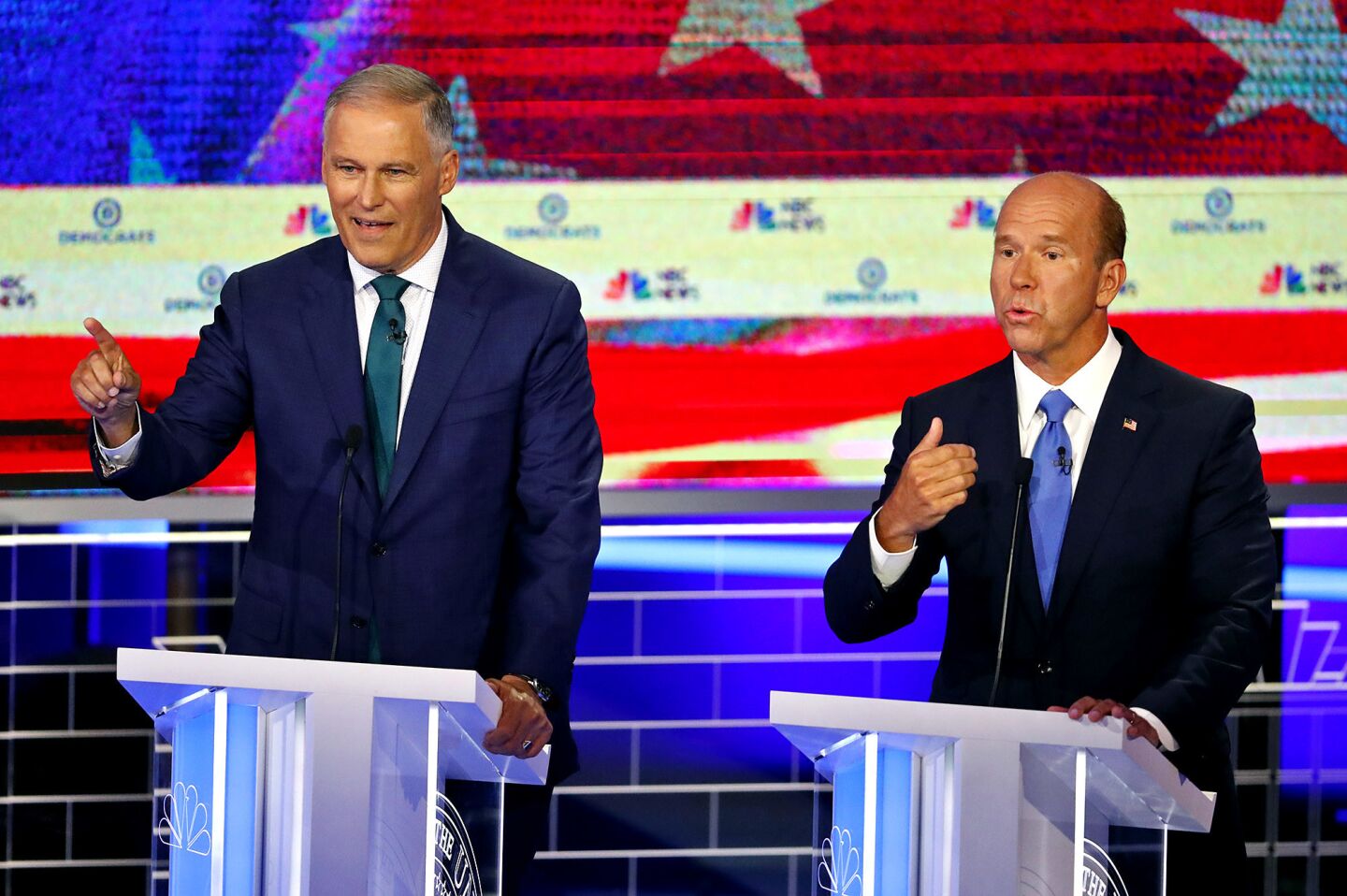 Democratic presidential candidates Washington Gov. Jay Inslee , left and former Maryland Rep. John Delaney answer a question at the same time during a Democratic primary debate hosted by NBC News at the Adrienne Arsht Center for the Performing Arts, Wednesday, June 26, 2019, in Miami.