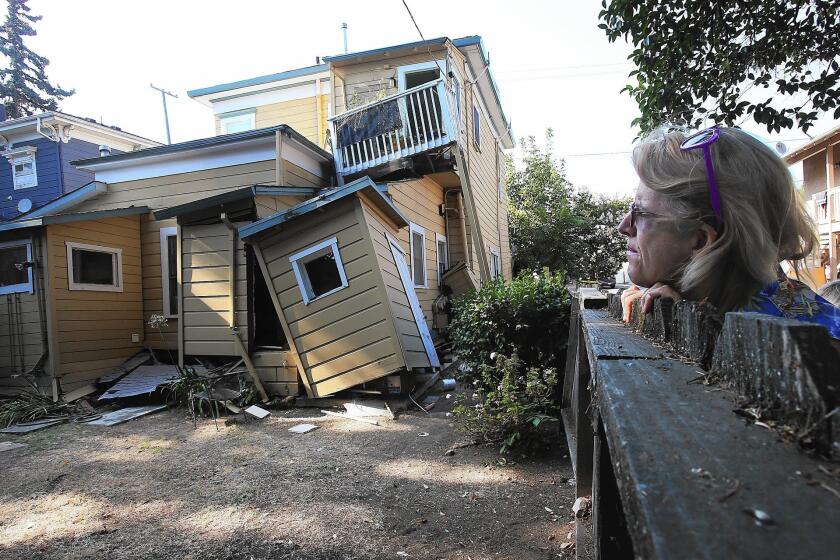 Vickie Katsubayashi checks out a red-tagged home near downtown Napa the day after the earthquake.