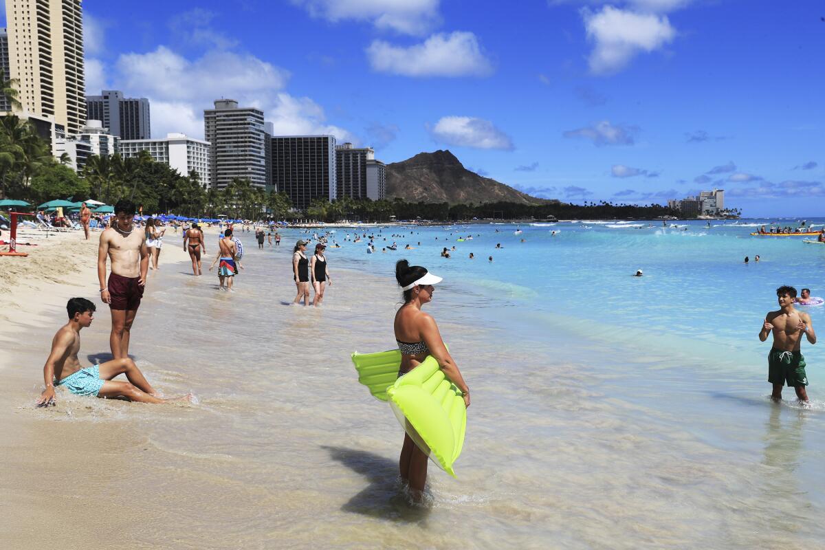 Beachgoers take to the waves on Waikiki Beach