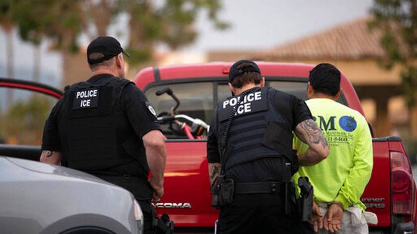 Agentes del Servicio de Control de Inmigración y Aduanas detienen a un hombre durante un operativo en Escondido, California.