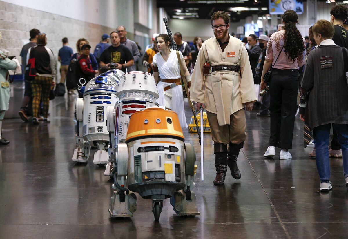 Operators from R2 Builders, drive a parade of remote controlled R2-D2 droids at Wondercon 2023 show in Anaheim on Sunday.