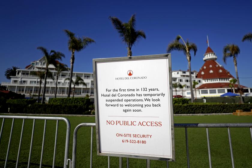 FILE - In this June 11, 2020 file photo a sign informing passersby of the hotel's closure is posted outside the Hotel Del Coronado in Coronado, Calif. California's unemployment rate has fallen to 11.4% in August. The Employment Development Department says the state added 101,900 jobs in August. Most of those were government jobs, including temporary positions for the U.S. Census. California lost more than 2.6 million jobs in March and April because of the coronavirus. (AP Photo/Gregory Bull, File)