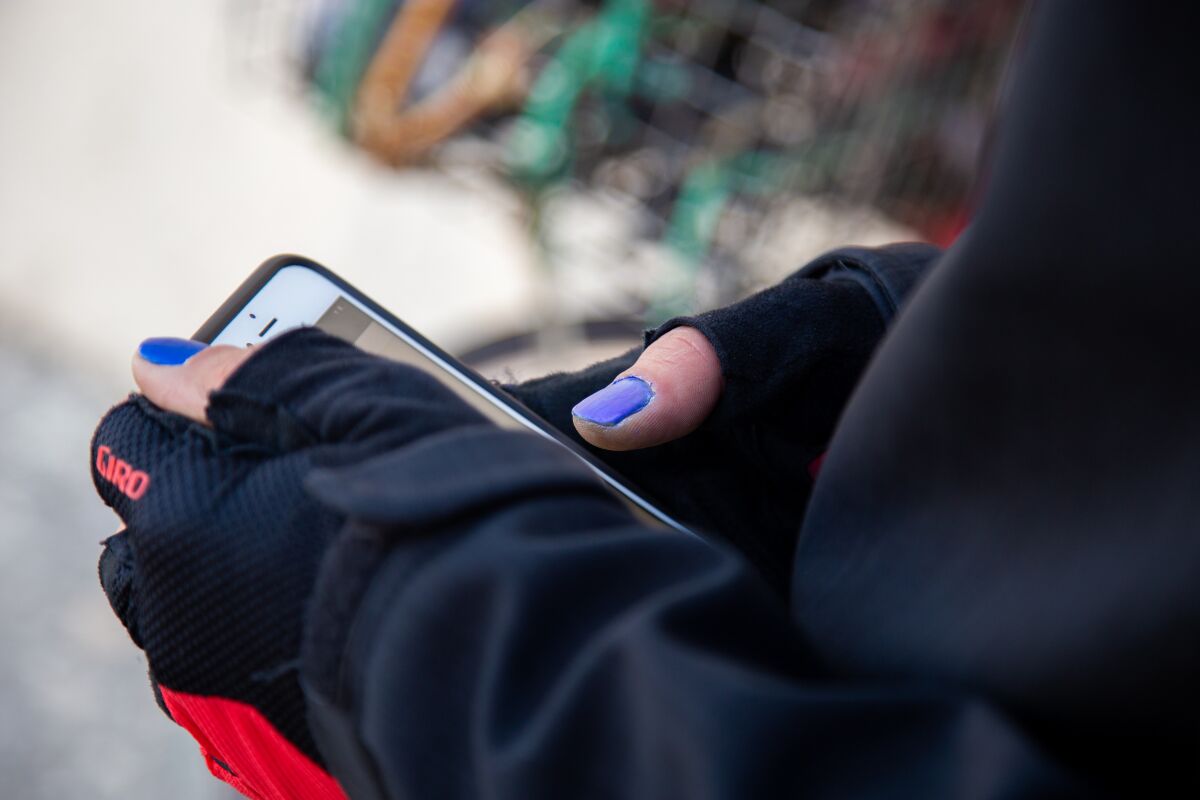 Justin Zemlyansky, a bike courier, checks his phone for incoming food delivery orders.