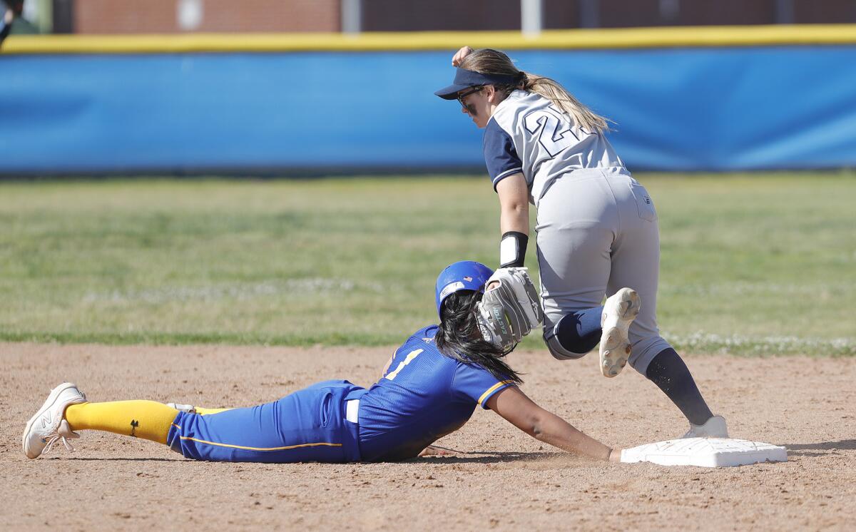 Newport Harbor's Dru Stinson (20) tags out Fountain Valley base runner Kira Velasco diving back to the bag.