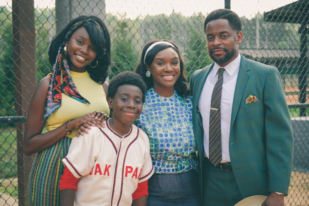 A Black family poses by a ball field in 1960s Alabama.