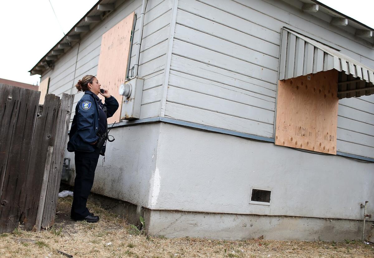 A code enforcement officer checks a meter at a foreclosed home in Richmond, Calif. The city is pressing ahead with a plan to buy or seize underwater home loans and write down the balances to lower payments for the homeowners.
