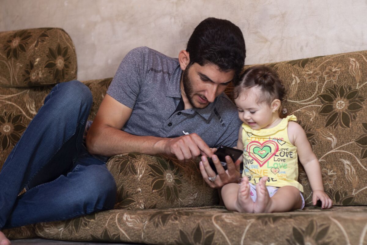 Abdel Hamid Yousef plays with his 11-month-old daughter, Aya, at a settlement for the displaced near the town of Atmeh in northern Syria on Sept. 1, 2019. He lost his twin infants, his wife and 16 other relatives in the poison gas attack that hit Syria’s Khan Sheikhoun in April 2017.