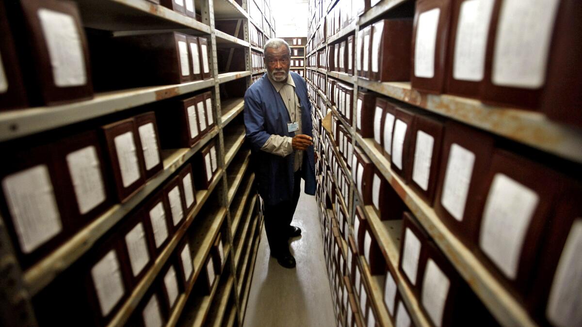 Cemetery caretaker Albert Gaskin stands in a room where hundreds of boxes are stored, each containing the ashes of a person who has been cremated by L.A. County.