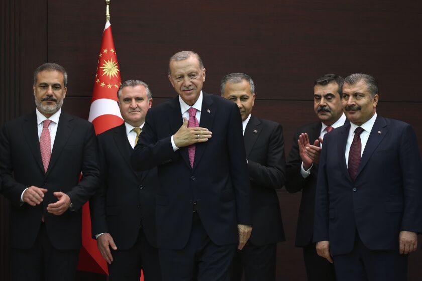 Turkish President Recep Tayyip Erdogan, center, stands with the new cabinet members during the inauguration ceremony at the presidential complex in Ankara, Turkey, Saturday, June 3, 2023. Erdogan, who was sworn into his third presidential term on Saturday, reappointed an internationally respected former banker as finance minister in a sign that his new government might pursue more conventional economic policies. (AP Photo/Ali Unal)