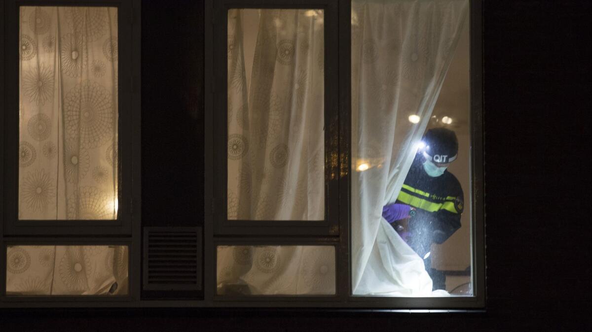 A forensics expert examines the house where a suspect in a deadly tram attack was arrested in Utrecht, Netherlands, on March 18.
