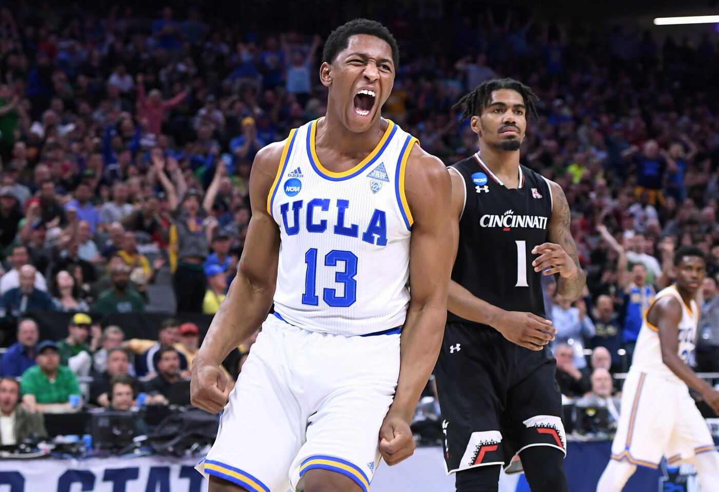UCLAA forward Ike Anigbogu celebrates after his dunk in front of Cincinnati guard Jacob Evans during the second half.