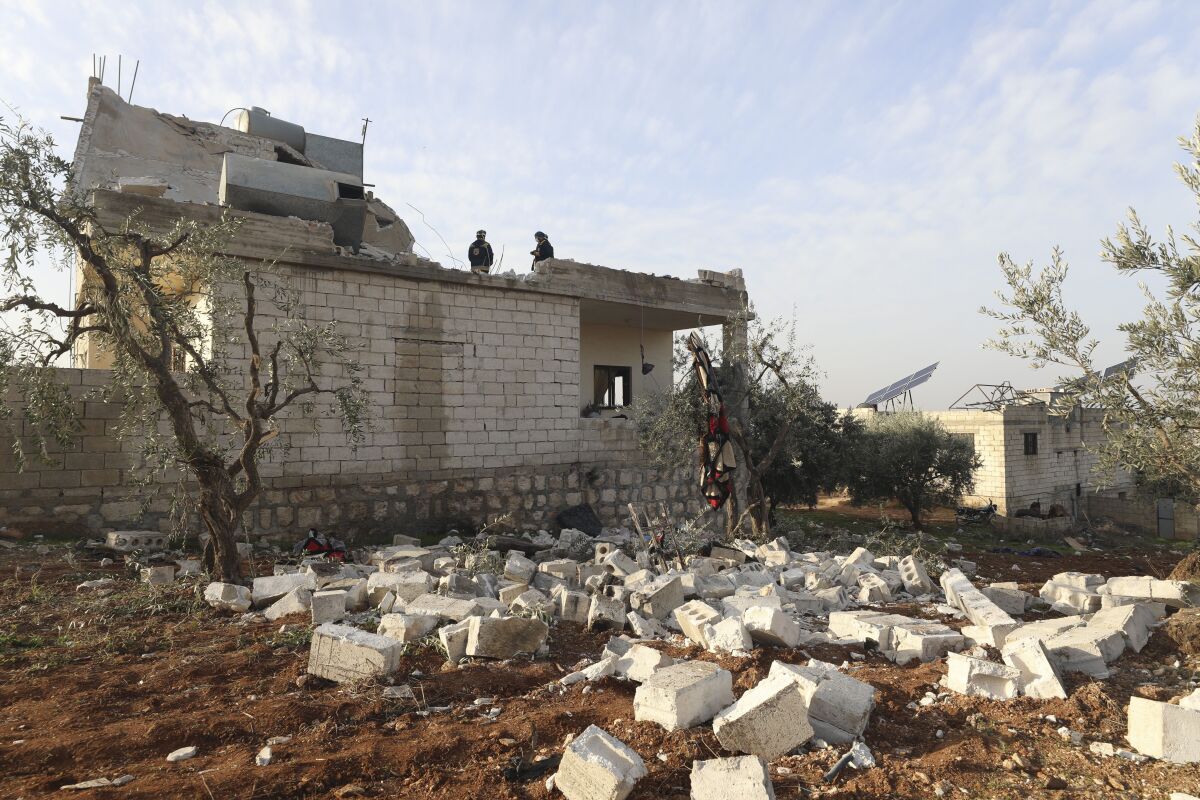 People check a destroyed house after an operation by the U.S. military in Syria on Thursday. 