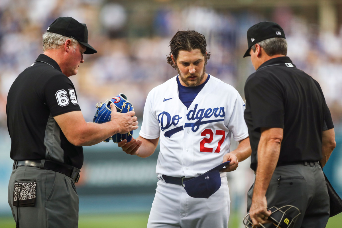 Umpires check the hat and glove of Trevor Bauer for foreign substances.