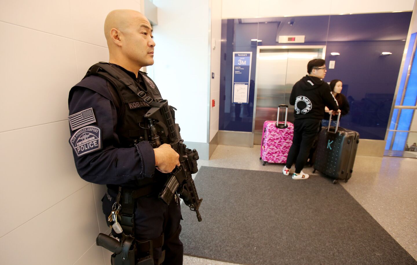 A heavily armed police officer stands guard at Los Angeles International Airport, where security personnel responded to the discovery of several suspicious paackages on Wednesday.