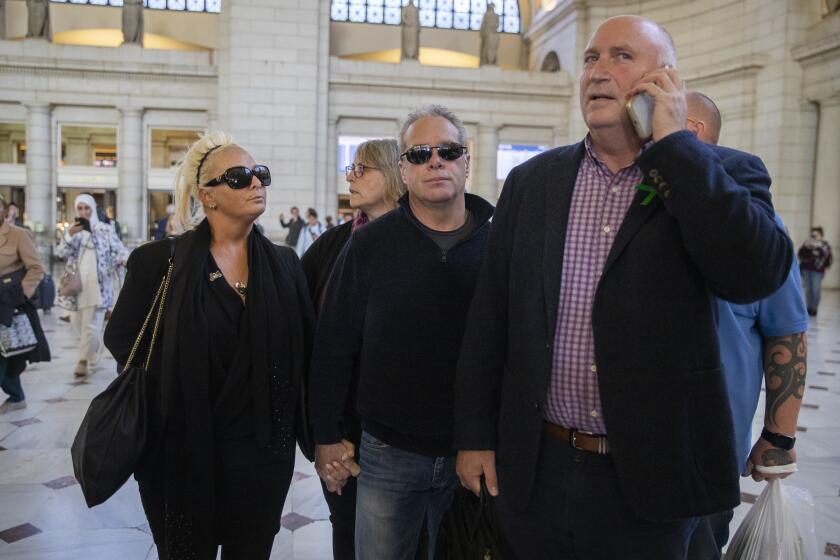 Charlotte Charles, left, mother of British teenager Harry Dunn, and her husband Bruce Charles, center arrive at Union Station in Washington, Tuesday, Oct. 15, 2019. The family of a British teenager killed in a car crash involving an American diplomat's wife was headed to the White House on Tuesday for a meeting with senior administration officials. On the phone is family spokesman Radd Seiger. (AP Photo/Manuel Balce Ceneta)
