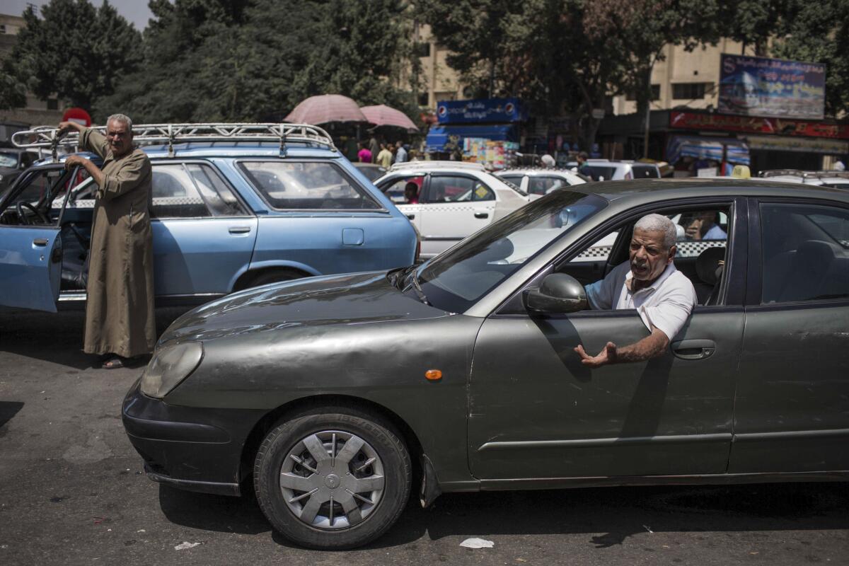 Drivers talk as they wait in line at a gas station, one of the Egyptian businesses affected by a power outage in Giza, Cairo's neighboring city, on Sept. 4.