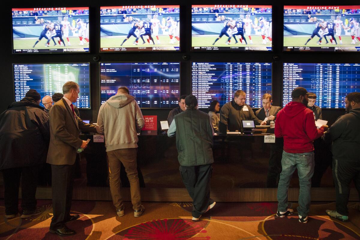 Gamblers place sporting bets at a casino in Philadelphia. Prop. 27 would legalize online sports betting in California. 