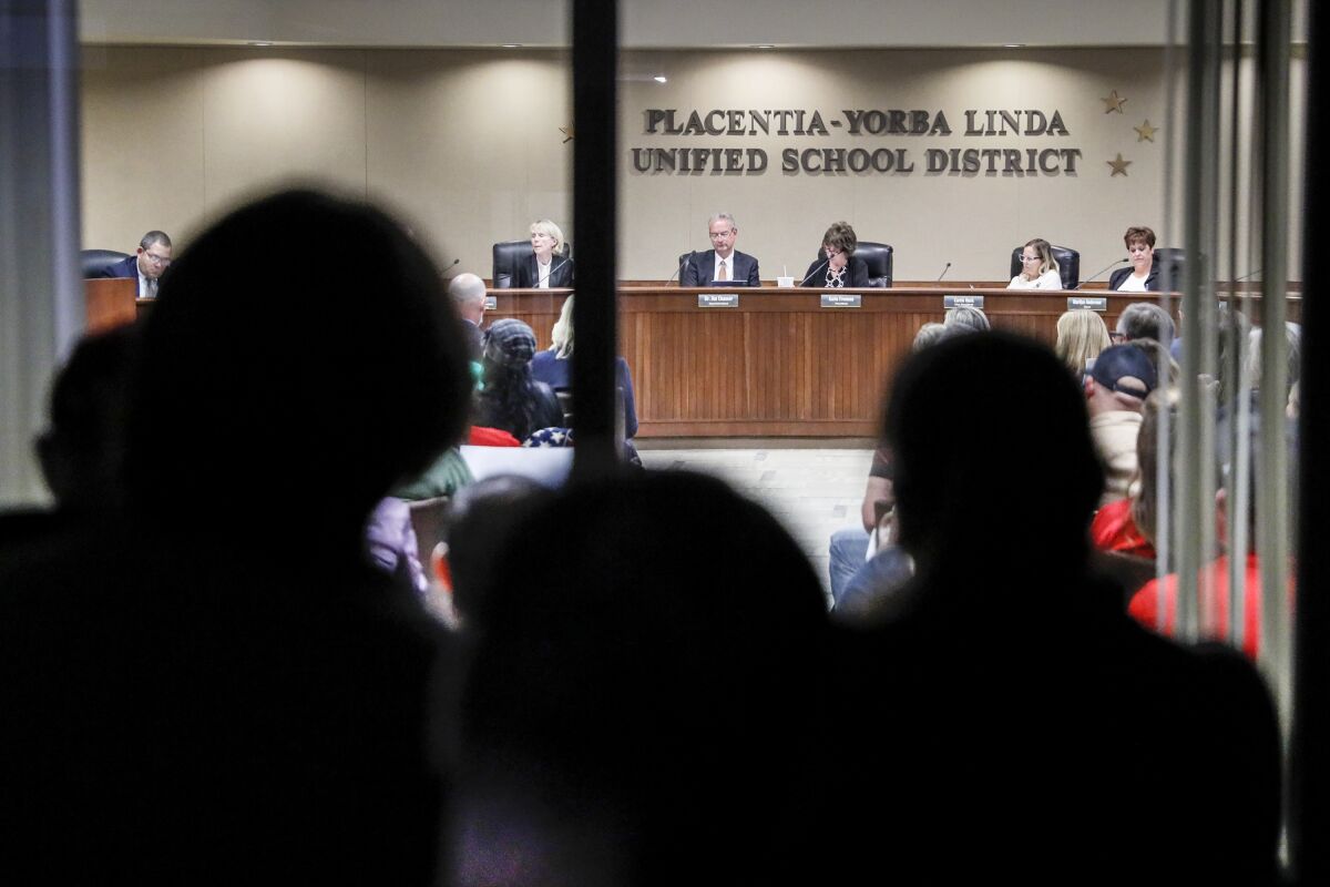 Spectators watch as an O.C. school board discusses a proposal to ban critical race theory