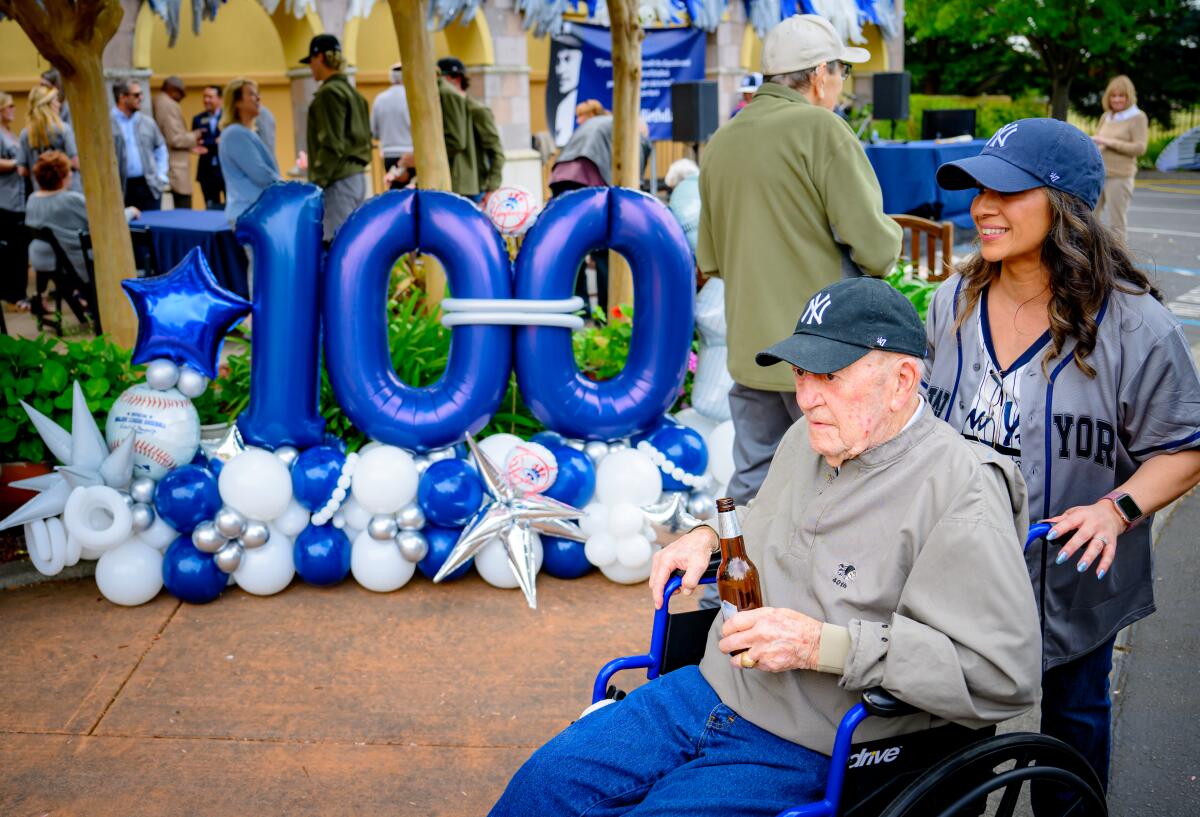 Art Schallock walks away in his wheelchair in front of a balloon display.