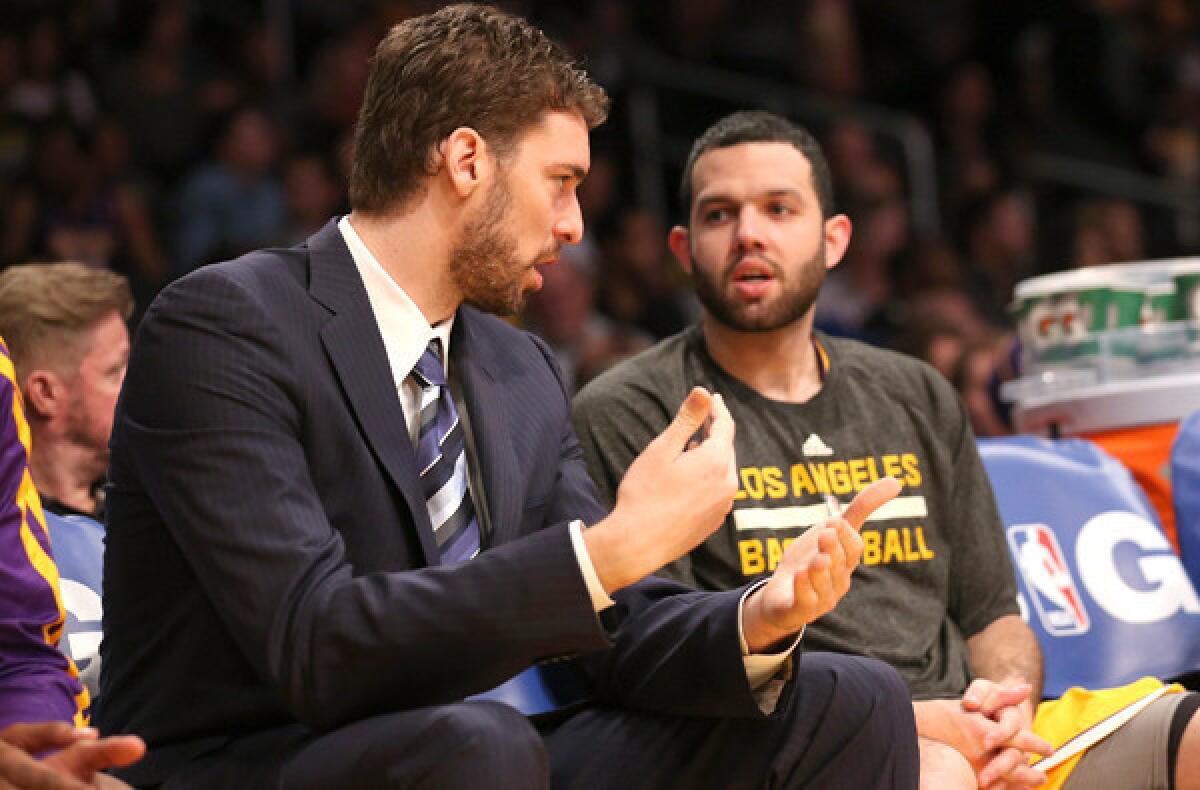 Lakers power forward Pau Gasol, sidelined because of a strained groin, chats with reserve point guard Jordan Farmar during the game Wednesday night at Staples Center.