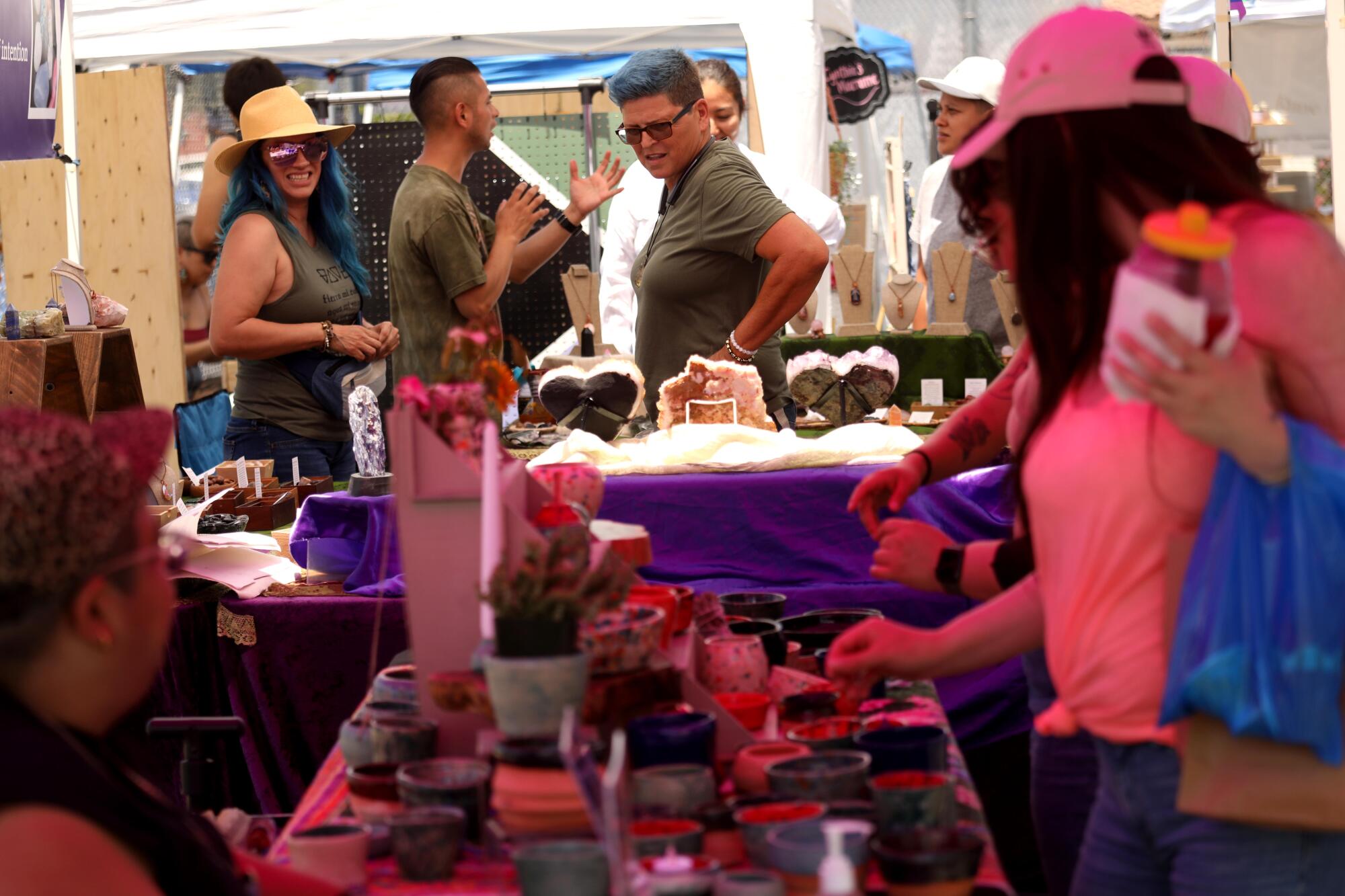 Shoppers visit a pair of booths at the Queer Mercado