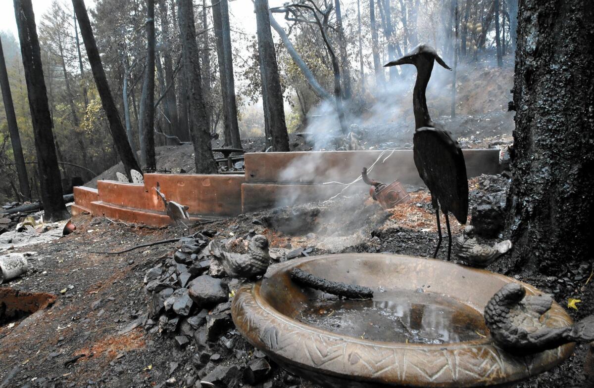 Smoke rises from the charred remains of a home and garden in Anderson Springs.