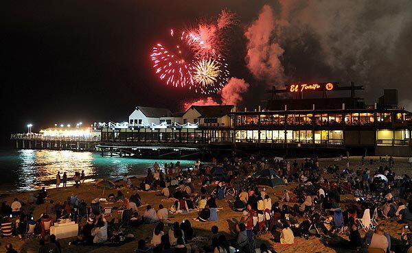 Spectators watch Fourth of July fireworks light up the sky over Redondo Beach Pier on Wednesday.