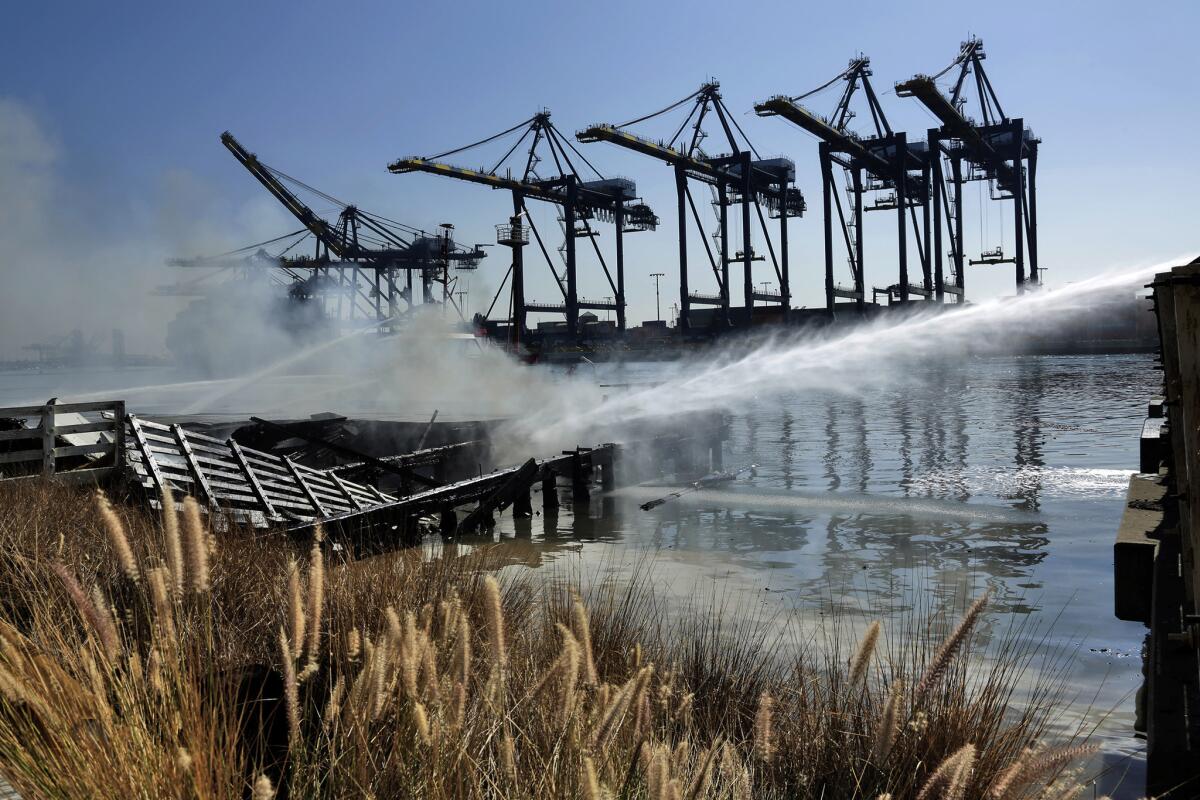 Fire crews spray water on a stubborn blaze at the Port of L.A. that sent toxic plumes of smoke into the air.
