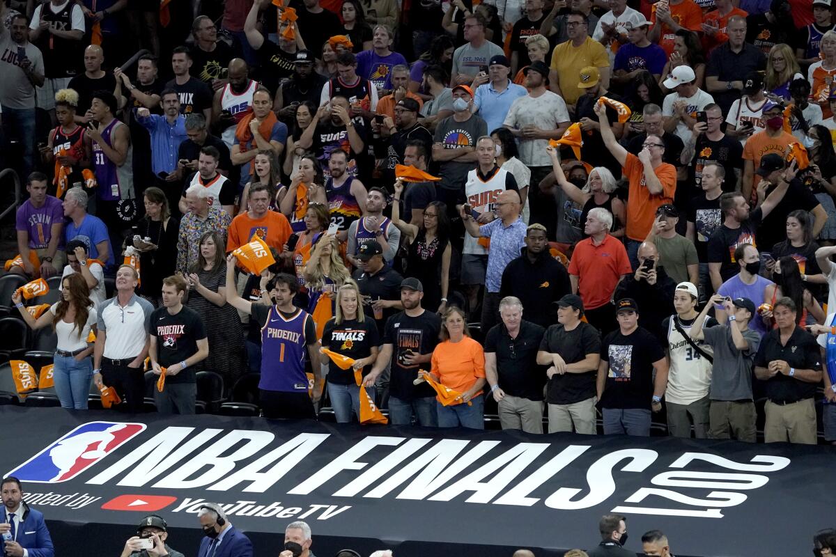 Fans cheer prior to game 1 of basketball's NBA Finals between the Milwaukee Bucks and the Phoenix Suns, Tuesday, July 6, 2021, in Phoenix. (AP Photo/Matt York, Pool)