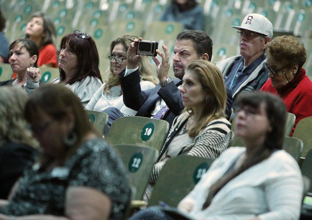 Burbank Unified School Board Vice President Armond Aghakhanian takes a picture of Carol Kocivar as she starts her presentation at a Community Engagement Night, hosted by the Burbank Council Parent Teacher Assn., at Luther Burbank Middle School on Wednesday.