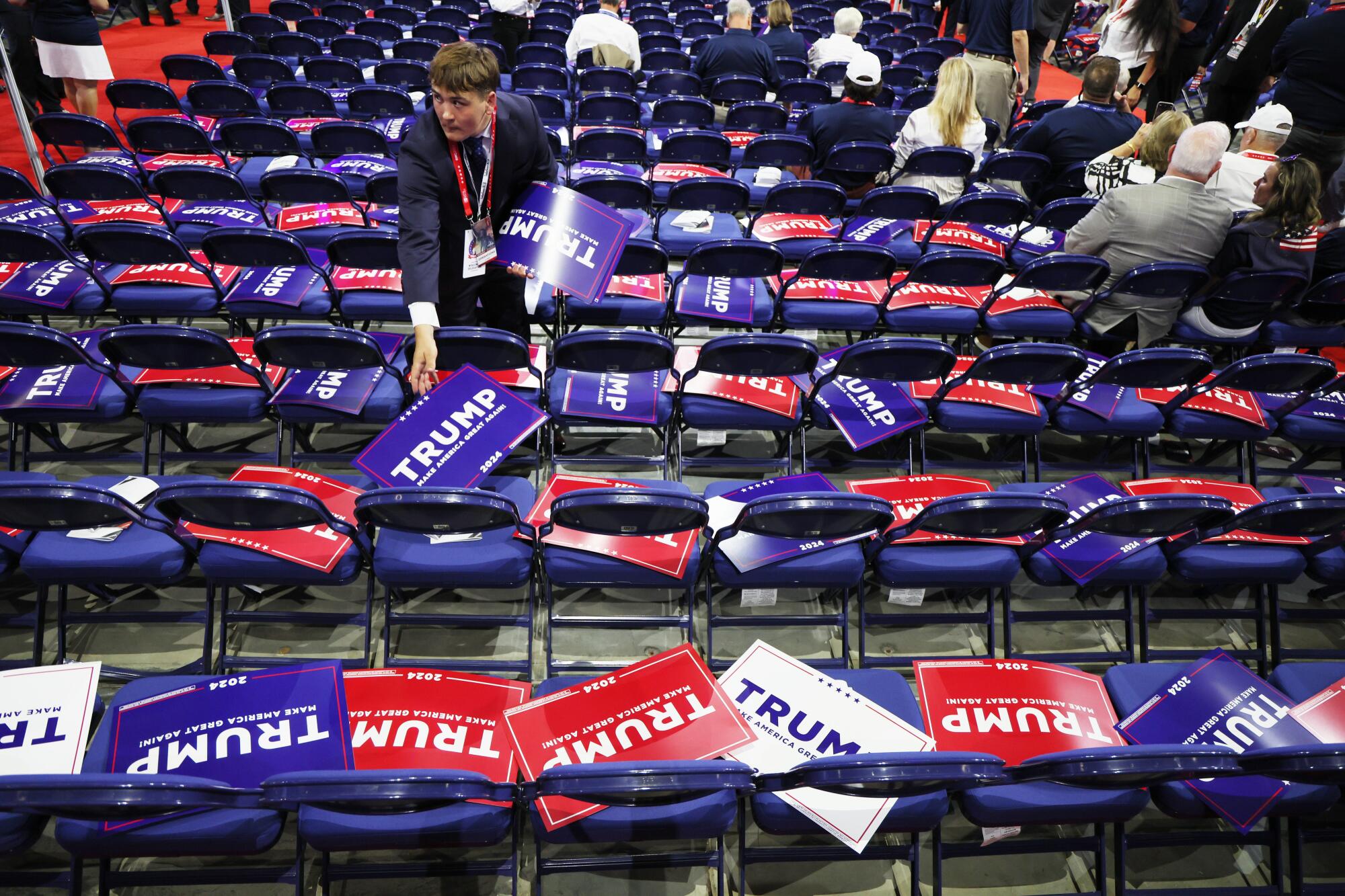 A worker lays out Trump signs during the 2024 Republican National Convention.