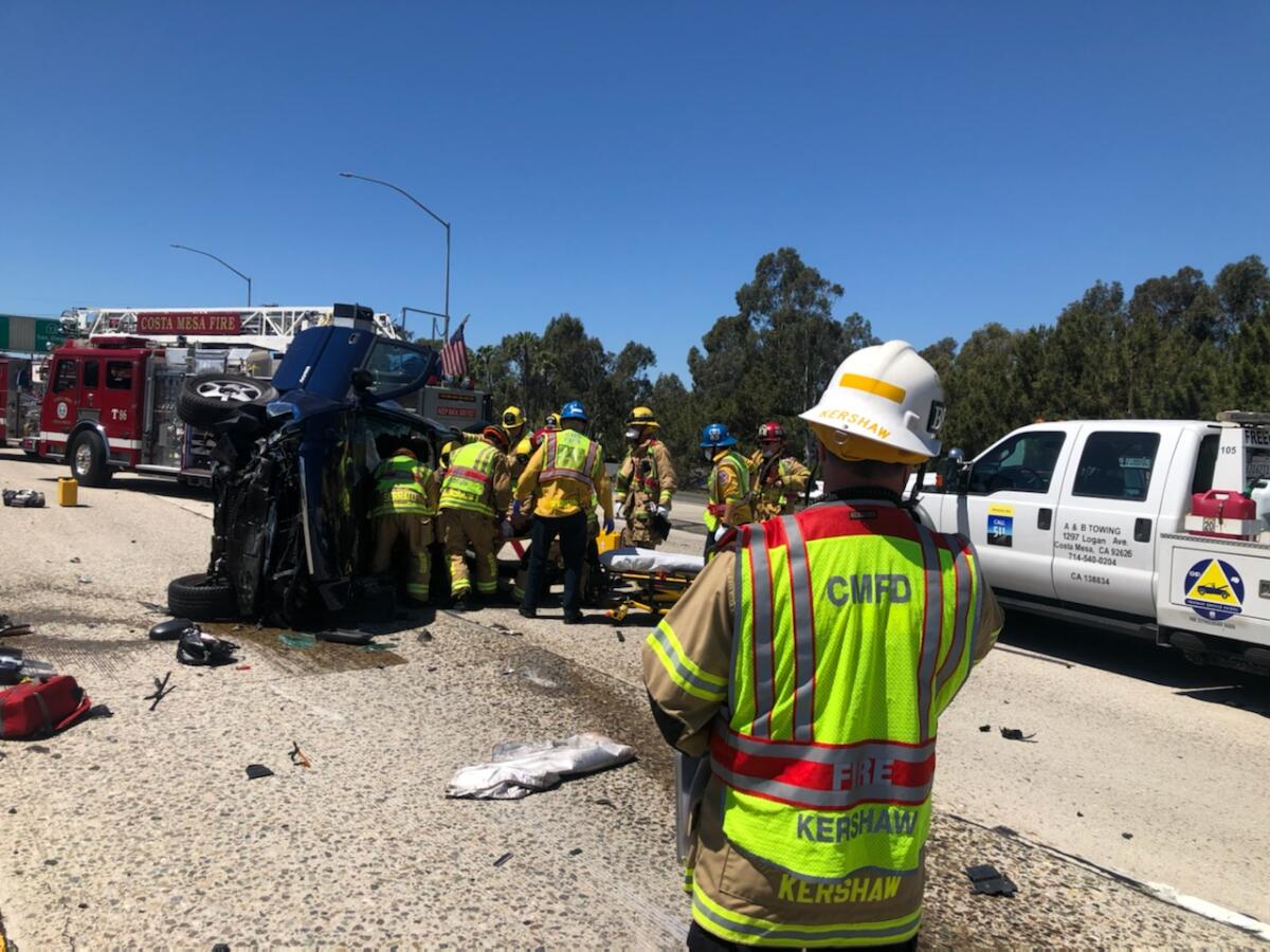 A woman was transported to a trauma center Thursday after her SUV hit a center divider on the 55 Freeway in Costa Mesa.