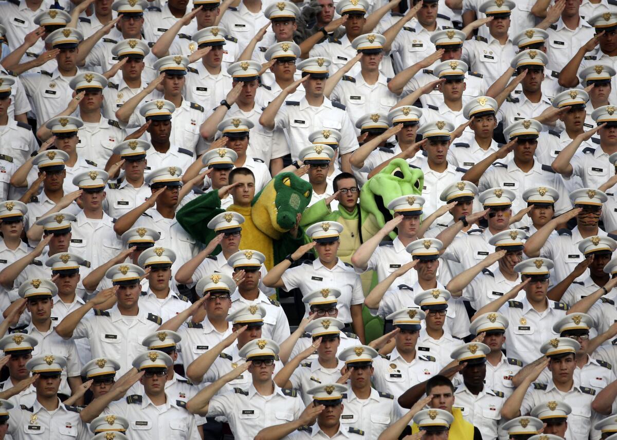 Cadets salute during the national anthem before a football game between Army and Fordham in West Point, N.Y.
