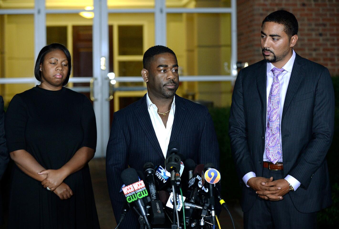 Rachel, left, and Ray Dotch, center, sister-in-law and brother-in-law to Keith Lamont Scott, give a news conference in Charlotte, N.C., on Saturday, Sept. 24, 2016. At right is the family's attorney, Justin Bamberg. Dotch objected to reporters' questions about Scott's background, saying he shouldn't have to "humanize in order for him to be treated fairly."
