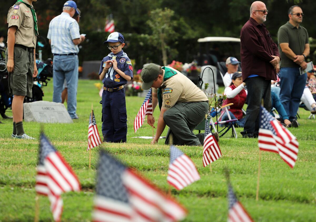 A Boy Scout from Troop 711 of Orange County, plants a U.S. flag.