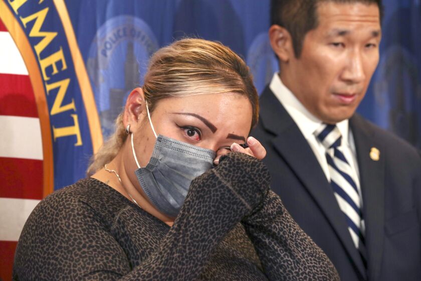 San Pedro, CA - September 30: Jenny Romero, left, mother of 12-year-old Alexander Alvarado killed in Wilmington in December 2021, wipes her tears after hearing arrests of suspects by LAPD. Romero, left, is flanked by Acting Special Agent in Charge Homeland Security Investigations, at press conference held at Harbor Community Police Station on Friday, Sept. 30, 2022 in San Pedro, CA. (Irfan Khan / Los Angeles Times)